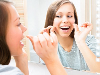 Woman flossing her teeth