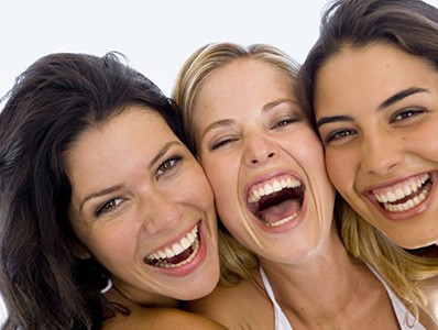 Friends smiling after Invisalign clear braces and cosmetic dentistry treatment