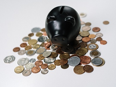 Black piggy bank and coins on white background