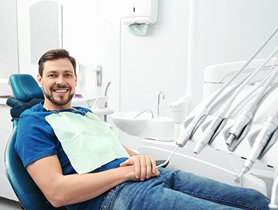 Male dental patient sitting in chair smiling