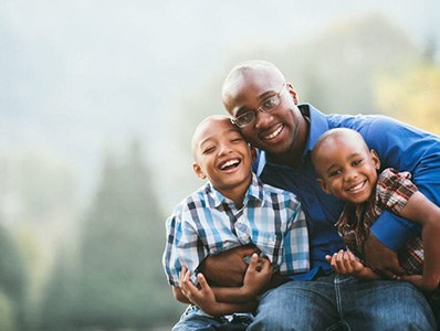 Father and children smiling together after family dentistry visit