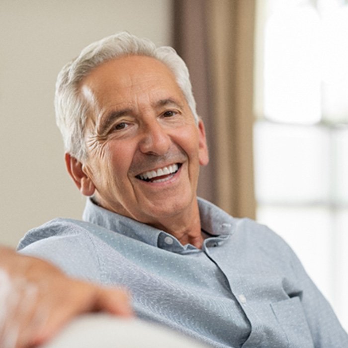 man smiling while sitting on couch 