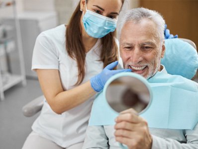 man smiling in dental mirror  