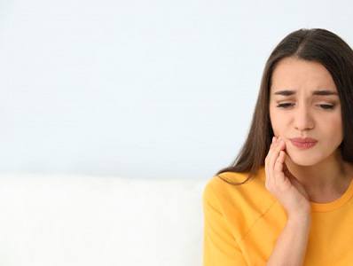 Woman in yellow t-shirt, suffering from mouth pain