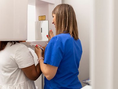Dental assistant taking a CBCT scan of a patient’s mouth