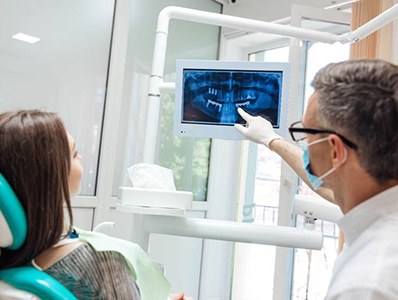 Dentist and patient looking at x-rays after dental implant placement