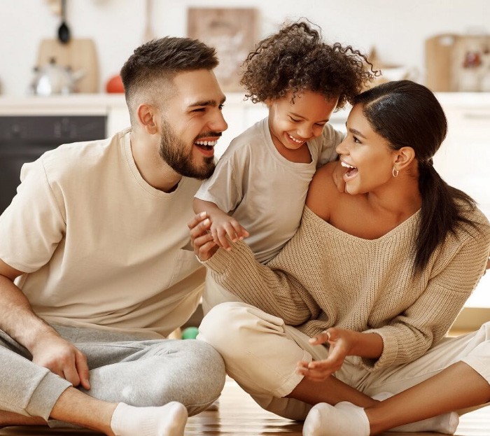 Mother father and young child laughing