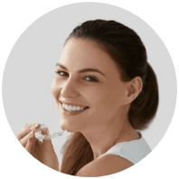 Smiling woman holding Invisalign clear braces tray