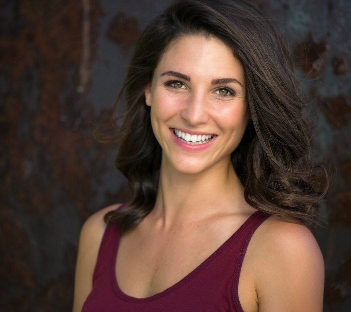 Smiling young woman in red sleeveless blouse