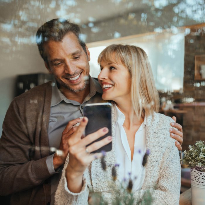 couple smiling and looking at phone