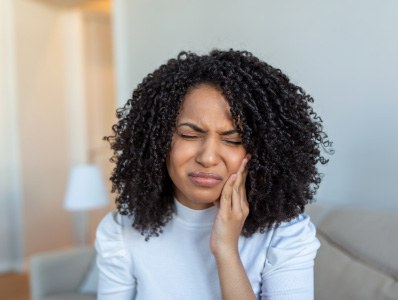 Woman holding her jaw in pain before emergency dentistry