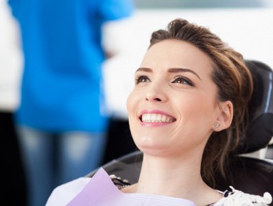 Woman smiling in dental chair during preventive dentistry visit