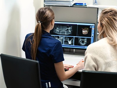 Dentist sitting at computer, planning patient’s treatment