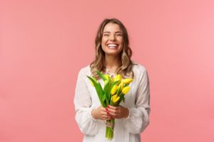 a woman smiling with spring flowers 