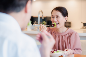 a person with dentures eating vegetables